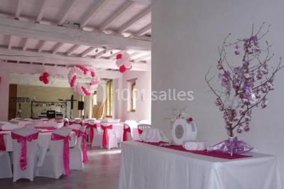 Vue sur les toits d'une ville avec un clocher en pierre et une tour en bois surmontée d'une cloche.
