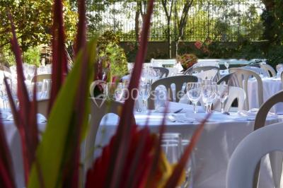 Vue sur les toits d'une ville avec un clocher en pierre et une tour en bois surmontée d'une cloche.