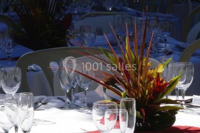 Vue sur les toits d'une ville avec un clocher en pierre et une tour en bois surmontée d'une cloche.