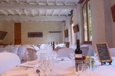 Entrée en briques rouges avec une porte verte ouverte et des lanternes suspendues à motifs zigzag.