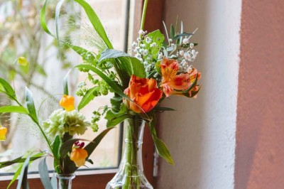 Entrée en briques rouges avec une porte verte ouverte et des lanternes suspendues à motifs zigzag.