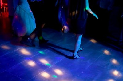 Entrée en briques rouges avec une porte verte ouverte et des lanternes suspendues à motifs zigzag.