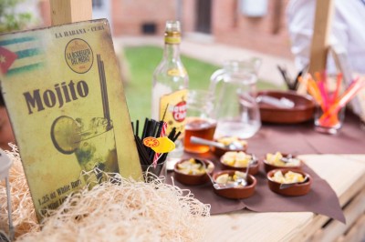 Entrée en briques rouges avec une porte verte ouverte et des lanternes suspendues à motifs zigzag.