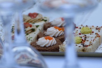 Entrée en briques rouges avec une porte verte ouverte et des lanternes suspendues à motifs zigzag.