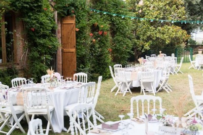 Entrée en briques rouges avec une porte verte ouverte et des lanternes suspendues à motifs zigzag.