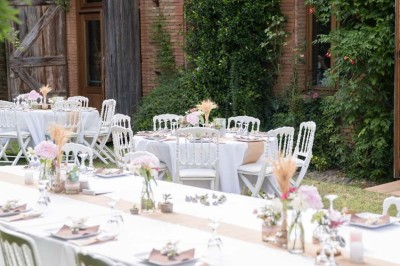 Entrée en briques rouges avec une porte verte ouverte et des lanternes suspendues à motifs zigzag.