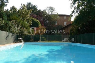 Vue sur les toits d'une ville avec un clocher en pierre et une tour en bois surmontée d'une cloche.