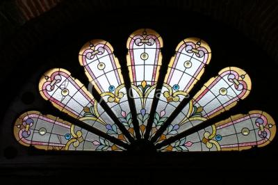 Vue sur les toits d'une ville avec un clocher en pierre et une tour en bois surmontée d'une cloche.