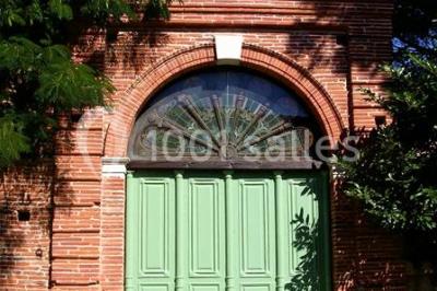 Vue sur les toits d'une ville avec un clocher en pierre et une tour en bois surmontée d'une cloche.