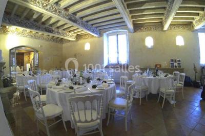 Vue sur les toits d'une ville avec un clocher en pierre et une tour en bois surmontée d'une cloche.