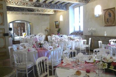 Vue sur les toits d'une ville avec un clocher en pierre et une tour en bois surmontée d'une cloche.