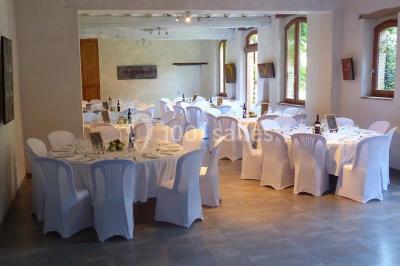 Vue sur les toits d'une ville avec un clocher en pierre et une tour en bois surmontée d'une cloche.
