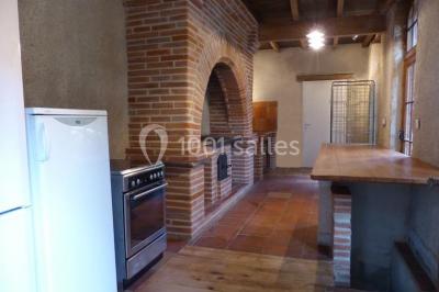 Vue sur les toits d'une ville avec un clocher en pierre et une tour en bois surmontée d'une cloche.