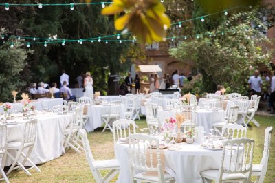 Entrée en briques rouges avec une porte verte ouverte et des lanternes suspendues à motifs zigzag.