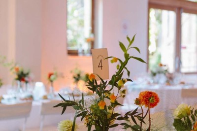 Entrée en briques rouges avec une porte verte ouverte et des lanternes suspendues à motifs zigzag.