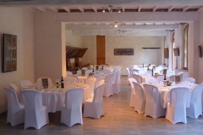 Entrée en briques rouges avec une porte verte ouverte et des lanternes suspendues à motifs zigzag.