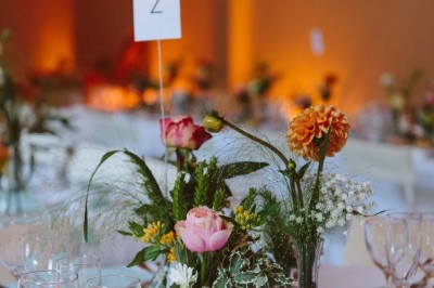 Entrée en briques rouges avec une porte verte ouverte et des lanternes suspendues à motifs zigzag.