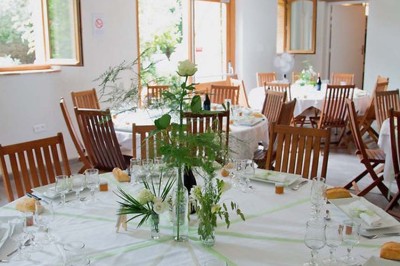 Entrée en briques rouges avec une porte verte ouverte et des lanternes suspendues à motifs zigzag.