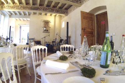 Entrée en briques rouges avec une porte verte ouverte et des lanternes suspendues à motifs zigzag.