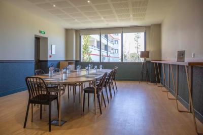 Vue d'un complexe résidentiel avec piscine, espaces verts et architecture méditerranéenne sous un ciel dégagé.