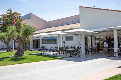 Vue d'un complexe résidentiel avec piscine, espaces verts et architecture méditerranéenne sous un ciel dégagé.