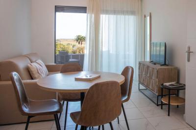 Vue d'un complexe résidentiel avec piscine, espaces verts et architecture méditerranéenne sous un ciel dégagé.