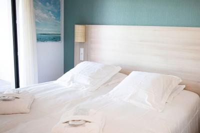 Vue d'un complexe résidentiel avec piscine, espaces verts et architecture méditerranéenne sous un ciel dégagé.