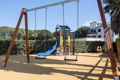 Vue d'un complexe résidentiel avec piscine, espaces verts et architecture méditerranéenne sous un ciel dégagé.