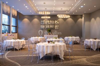 Bain à remous entouré de plantes et de transats sur une terrasse en bois avec vue dégagée.