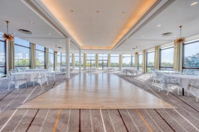 Bain à remous entouré de plantes et de transats sur une terrasse en bois avec vue dégagée.