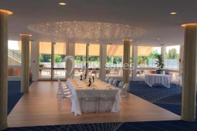 Bain à remous entouré de plantes et de transats sur une terrasse en bois avec vue dégagée.