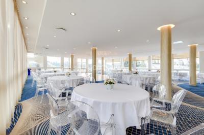 Bain à remous entouré de plantes et de transats sur une terrasse en bois avec vue dégagée.