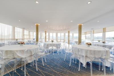 Bain à remous entouré de plantes et de transats sur une terrasse en bois avec vue dégagée.