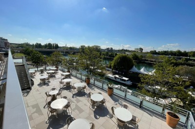 Bain à remous entouré de plantes et de transats sur une terrasse en bois avec vue dégagée.
