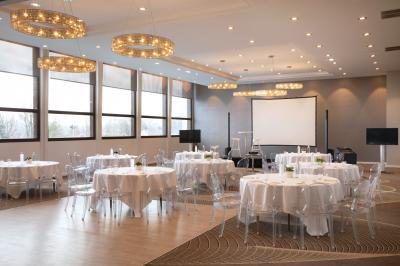 Jacuzzi extérieur entouré de plantes et de chaises longues sur une terrasse avec un panneau en bois.