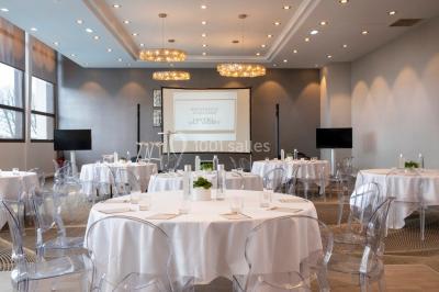 Jacuzzi extérieur entouré de plantes et de chaises longues sur une terrasse avec un panneau en bois.