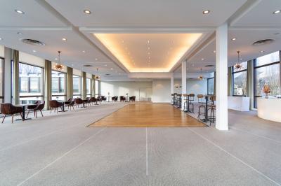 Jacuzzi extérieur entouré de plantes et de chaises longues sur une terrasse avec un panneau en bois.