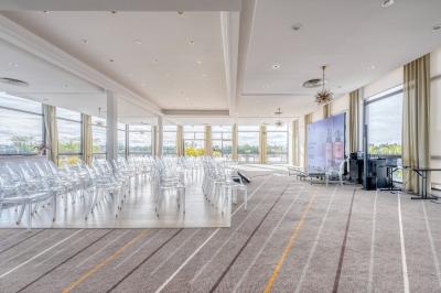 Jacuzzi extérieur entouré de plantes et de chaises longues sur une terrasse avec un panneau en bois.