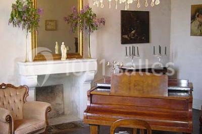 Façade d'un bâtiment éclairé en bleu la nuit, avec une fontaine au premier plan.