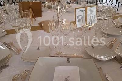 Façade d'un bâtiment éclairé en bleu la nuit, avec une fontaine au premier plan.