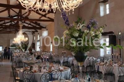 Façade d'un bâtiment éclairé en bleu la nuit, avec une fontaine au premier plan.