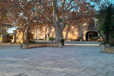 Colonne en pierre sur un socle dans un parc arboré, entourée de pelouse et d'arbres feuillus.