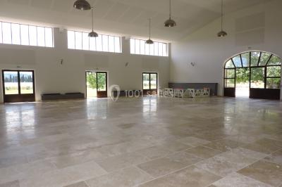 Colonne en pierre sur un socle dans un parc arboré, entourée de pelouse et d'arbres feuillus.
