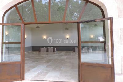 Colonne en pierre sur un socle dans un parc arboré, entourée de pelouse et d'arbres feuillus.