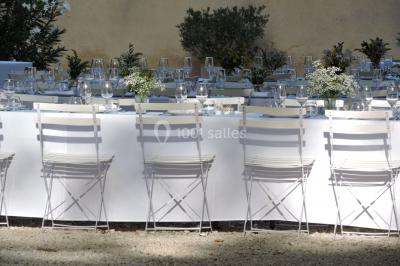 Colonne en pierre sur un socle dans un parc arboré, entourée de pelouse et d'arbres feuillus.