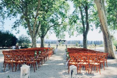 Colonne en pierre sur un socle dans un parc arboré, entourée de pelouse et d'arbres feuillus.