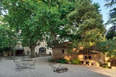 Colonne en pierre sur un socle dans un parc arboré, entourée de pelouse et d'arbres feuillus.
