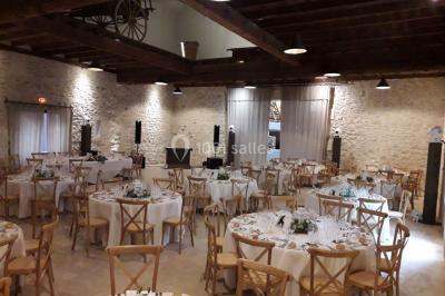 Colonne en pierre sur un socle dans un parc arboré, entourée de pelouse et d'arbres feuillus.