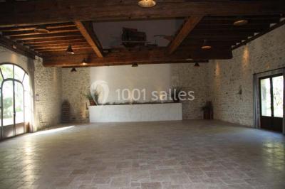 Colonne en pierre sur un socle dans un parc arboré, entourée de pelouse et d'arbres feuillus.