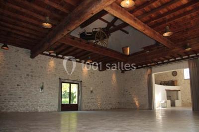 Colonne en pierre sur un socle dans un parc arboré, entourée de pelouse et d'arbres feuillus.